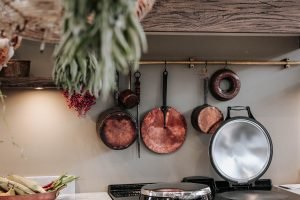 Copper pans hang on a kitchen wall.