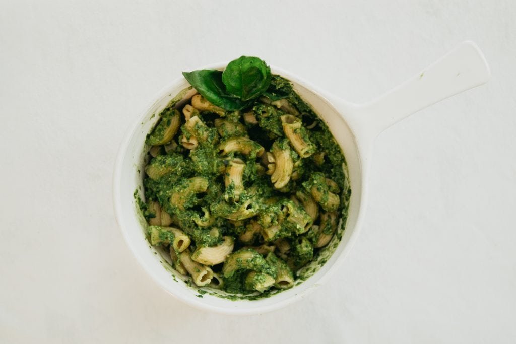 A dish containing Banza chickpea noodles coated in vegan basil pesto.
