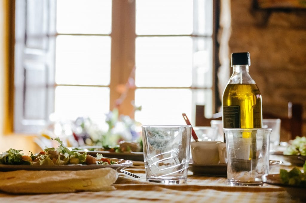 Olive oil bottle on a busy kitchen counter.