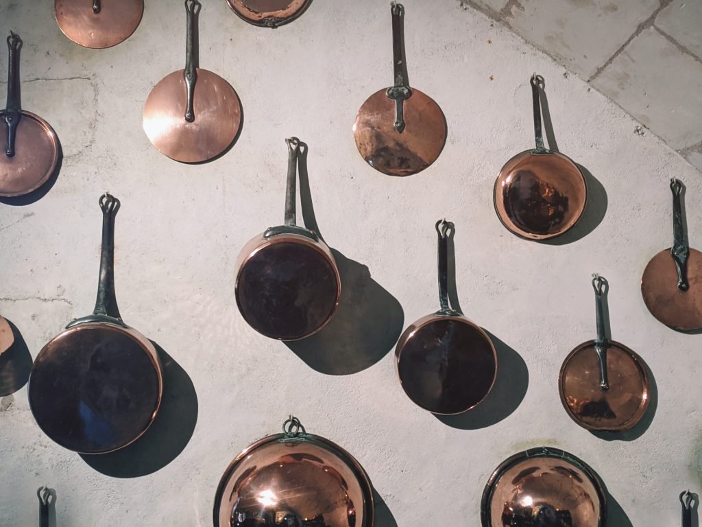 Copper pans hanging on a wall.