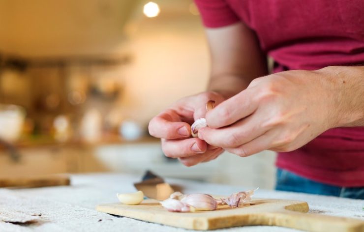 man peeling garlic