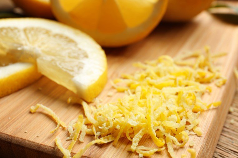 yellow lemon zest on a wooden cutting board
