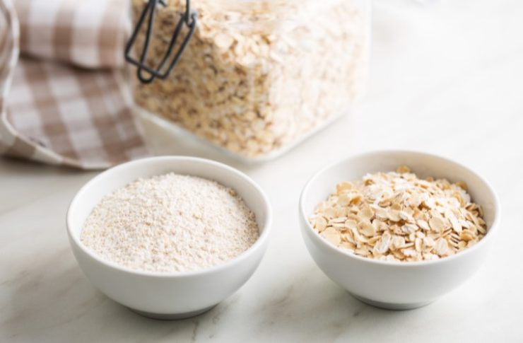 two white round shaped bowls filled with oats and oat flour