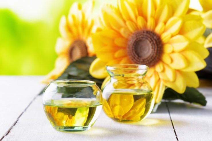 sunflower oil in two jugs and sunflower behind them