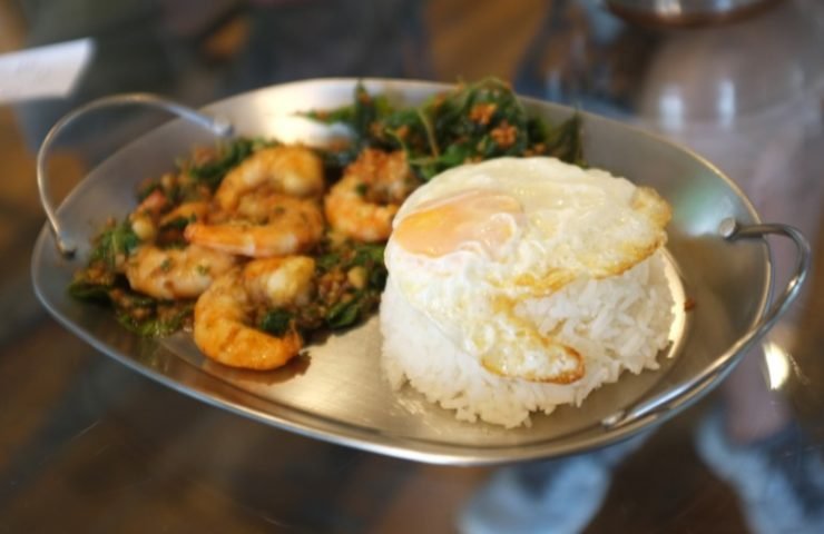 Stirred-fry shrimps or prawns with basil leaves, fried egg over rice.