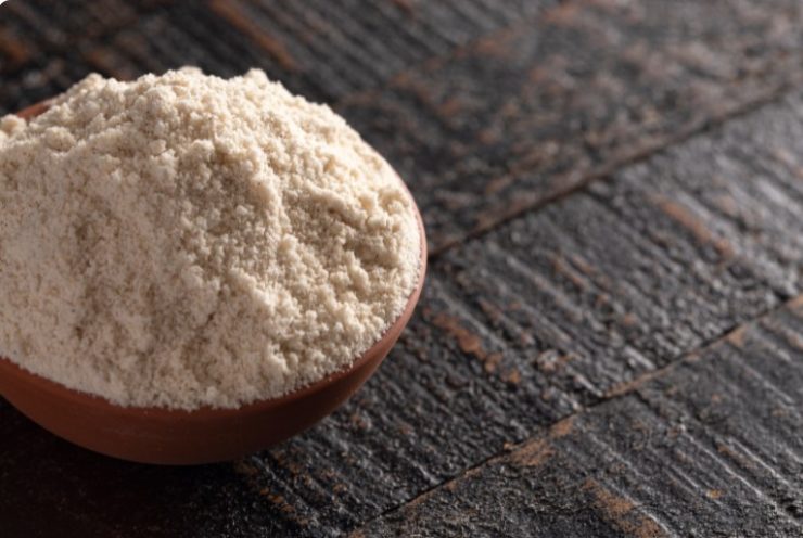 A Bowl of Sprouted Sorghum Flour on a Dark Wood Background