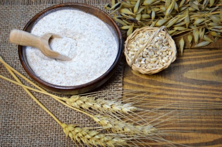 bowl with whole wheat flour and wheat seed next to it