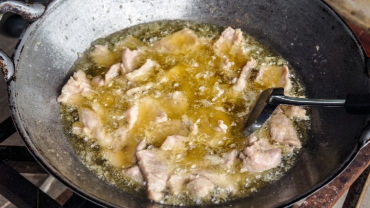 slice pork deep frying in a wok