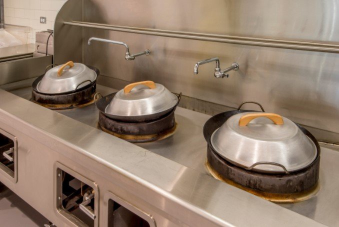 row of wok on a stove