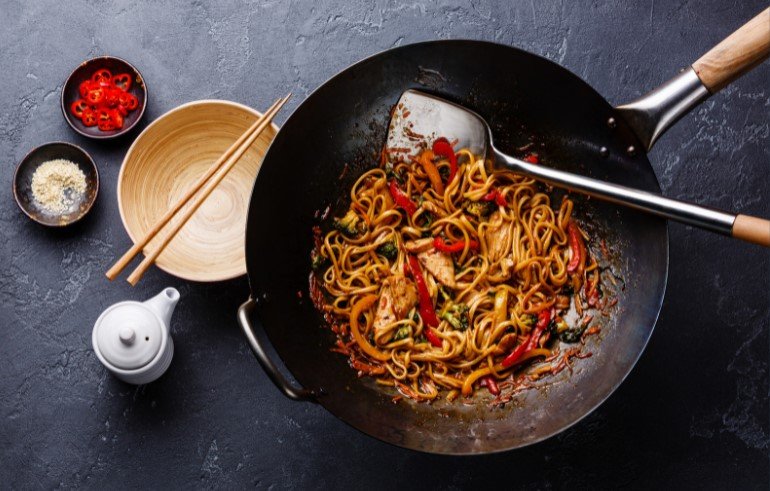 Udon stir-fry noodles with chicken and vegetables in a wok