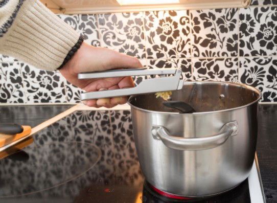 man adding garlic to a pot