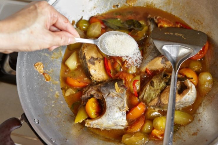 chef adding sugar to spicy food