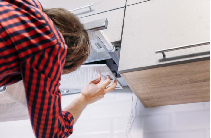 woman instaling a range hood 