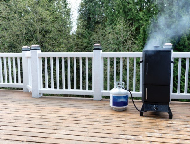 Smoker with Fresh Smoke Coming Out of BBQ Cooker on Outdoor Deck