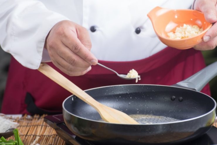 Chef putting minced garlic for cooking Pad Thai