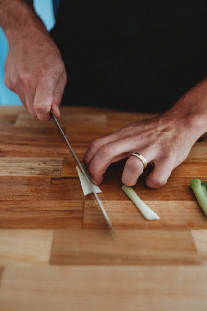 person cutting green onions into julienne