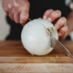 person curling finger when cutting onions