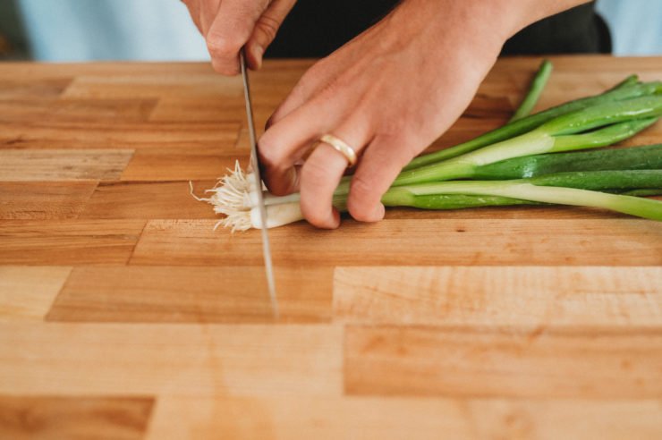 person startting to cut green onions