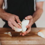 person peeling onions by hand