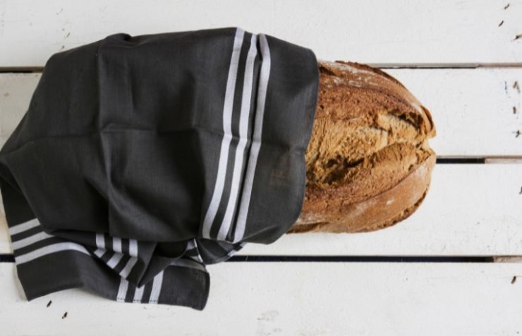 Bread Wrapped in Striped Fabric on White Wooden Table