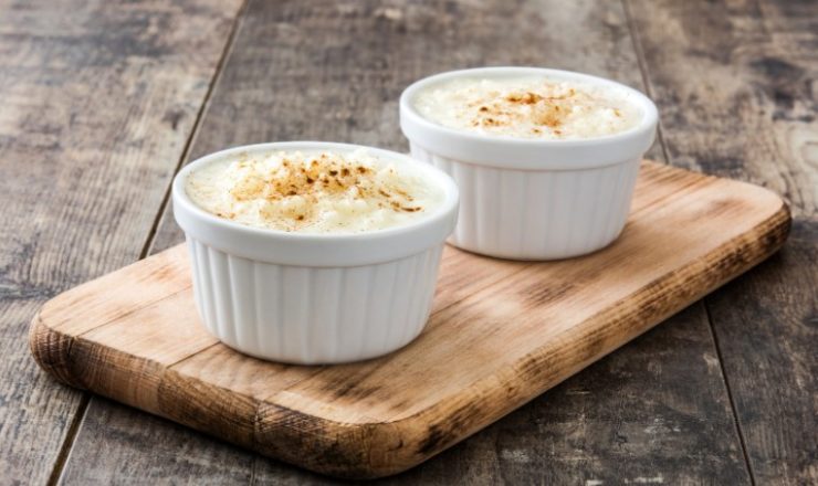 Arroz con leche. Rice pudding with cinnamon on wooden background