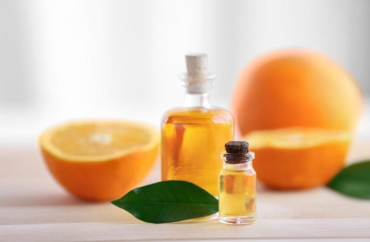 Bottles with Essential Oil and Oranges on the Table