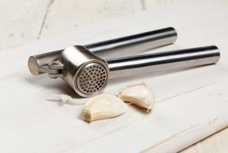 Garlic Press and clove of garlic