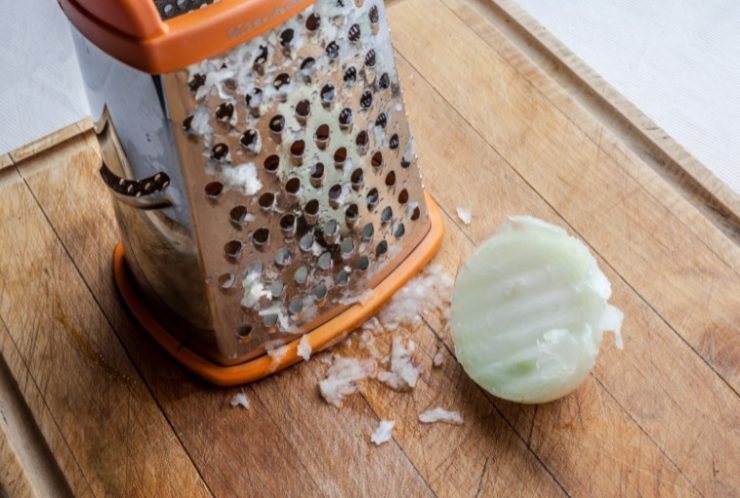Grated onion and grater on cutting board