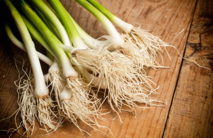 green garlic on a wooden surface