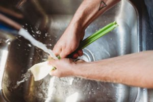 peron washing celery upon the sink