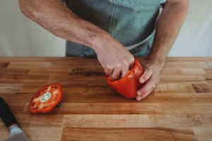 person taking out core of bell pepper