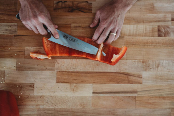 cutting white ribs out of a bell pepper