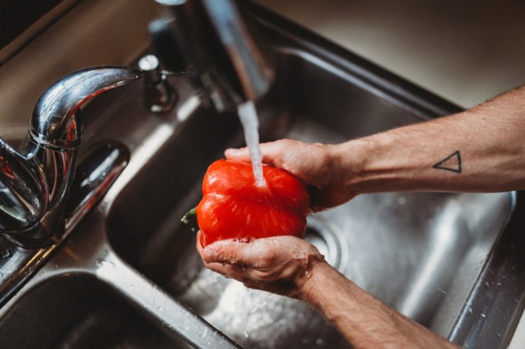 person washing bell pepper