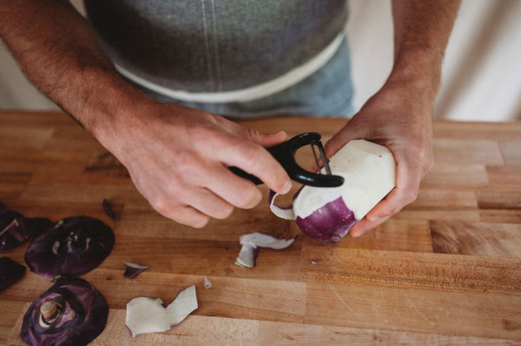 peeling kohlrabi with vegetable peeler