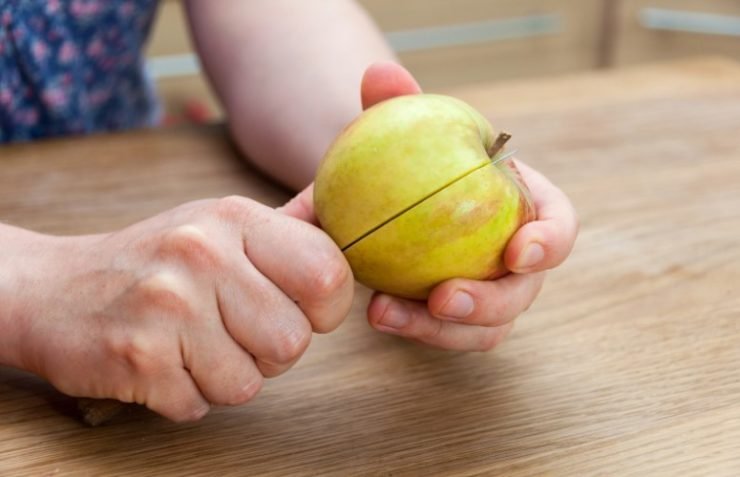 person cutting apple with a knife