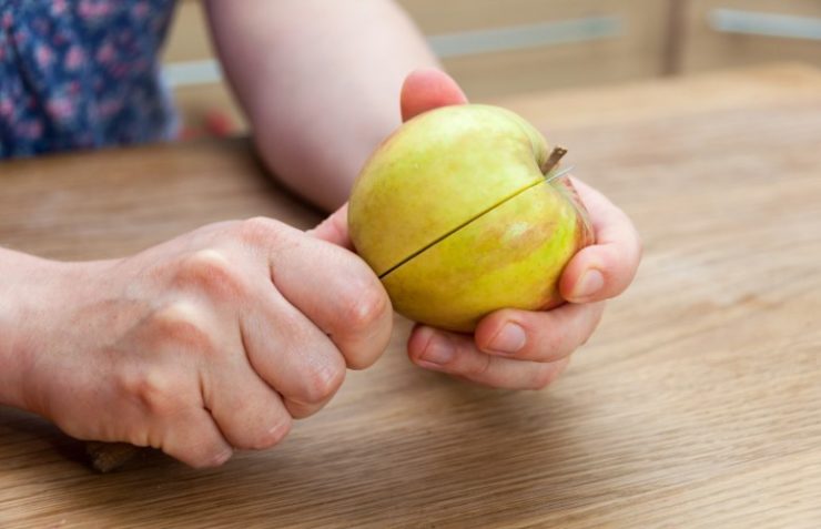 person cutting apple with a knife