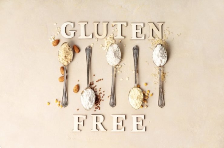 Metal Spoons of Various Gluten Free Flour Almond Flour, Oatmeal Flour, Buckwheat Flour, Rice Flour, Corn Flour and Gluten Free Lettering Made of Wooden Letters, Flat Lay, Top View