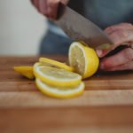 person cutting round lemons