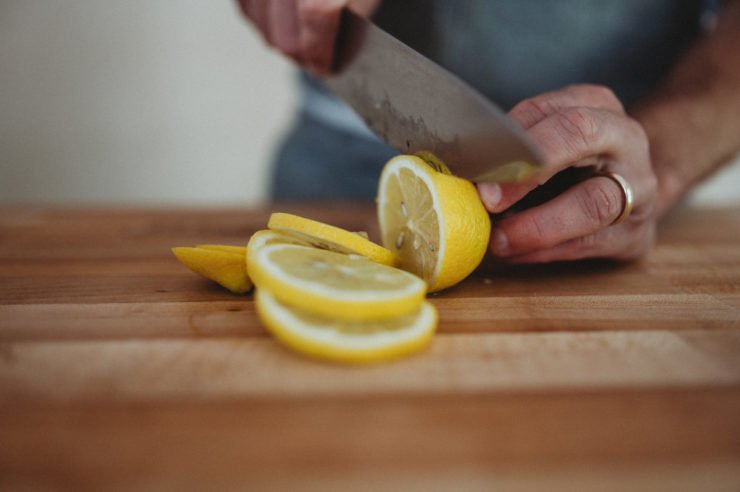 person cutting round lemons