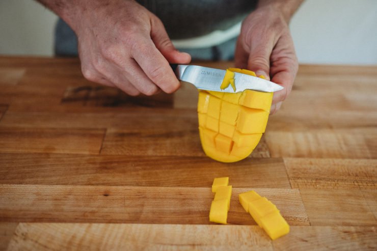 person cutting mango