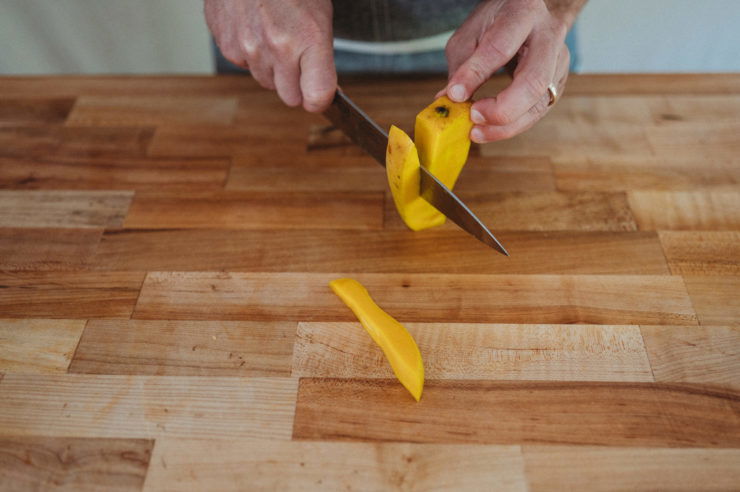 person cutting mango