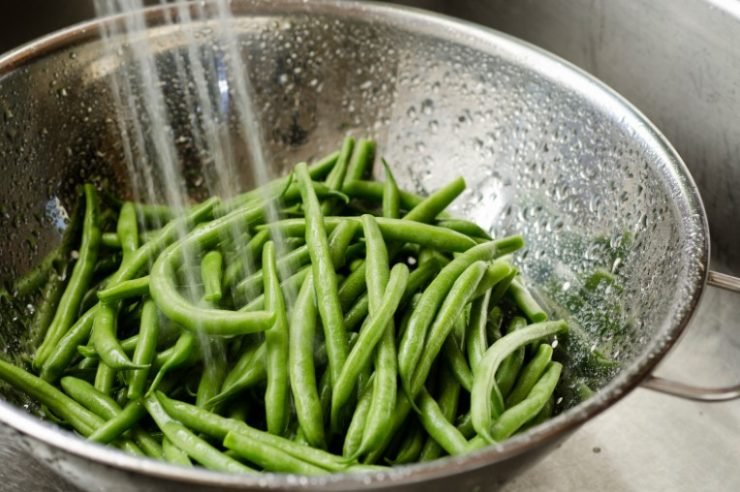 green beans being washed in a bowl