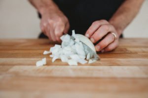 cutting onions on awooden cutting board