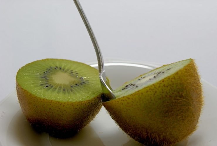 peeling kiwi with a spoon