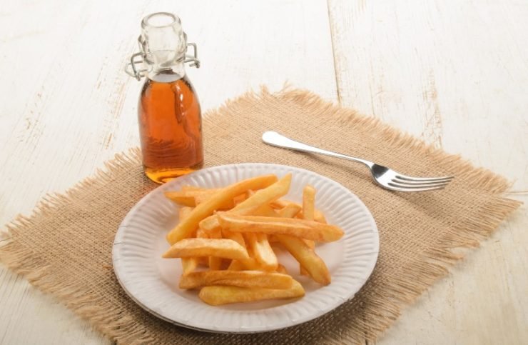 french fries on a paper plate and malt vinegar