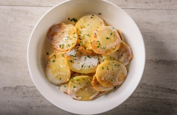 white bowl with Scalloped Potatoes