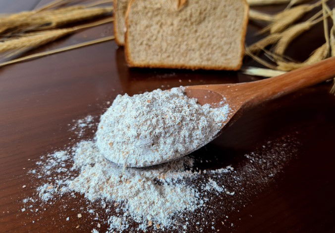 wooden spoon with whole grain flour